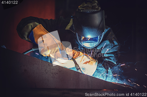 Image of worker welding metal