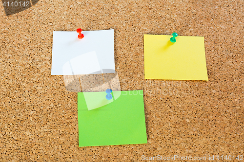 Image of Thumbtack pins and notepaper on pinboard