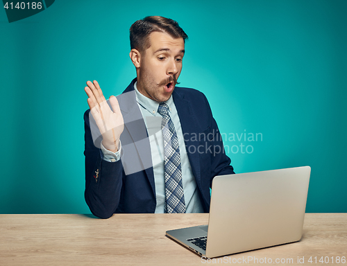 Image of Sad Young Man Working On Laptop At Desk