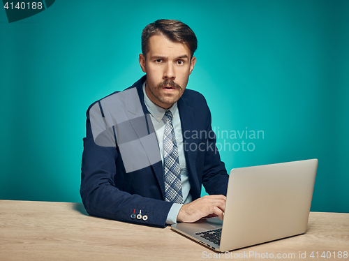 Image of Sad Young Man Working On Laptop At Desk