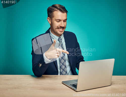 Image of Sad Young Man Working On Laptop At Desk