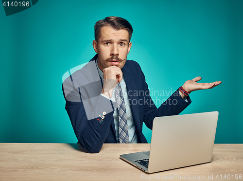 Image of Sad Young Man Working On Laptop At Desk