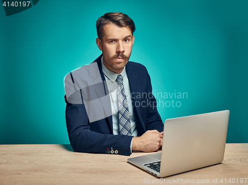 Image of Sad Young Man Working On Laptop At Desk