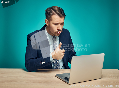 Image of Sad Young Man Working On Laptop At Desk