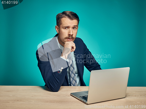 Image of Sad Young Man Working On Laptop At Desk