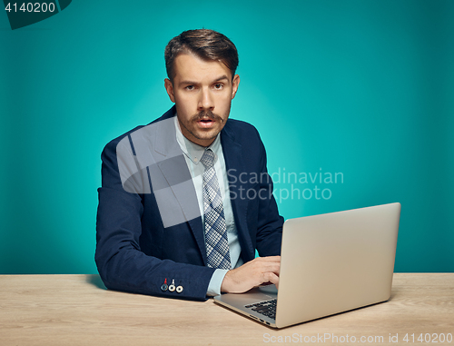 Image of Sad Young Man Working On Laptop At Desk