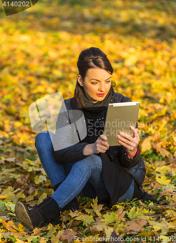 Image of Woman with a Tablet in a Forest in the Autumn