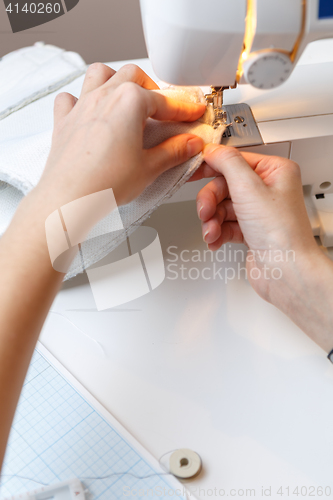 Image of Seamstress makes stitch on sewing-machine