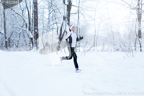 Image of Girl running in winter woods
