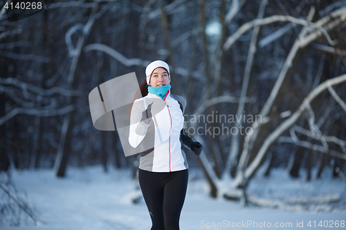 Image of Woman jogging on winter forest