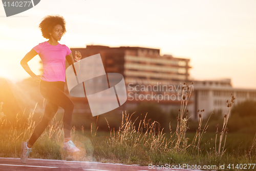 Image of a young African American woman jogging outdoors