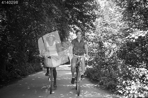 Image of Young multiethnic couple having a bike ride in nature