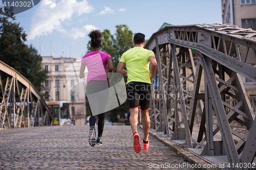 Image of multiethnic couple jogging in the city