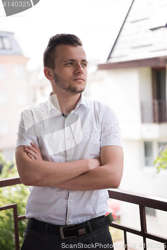 Image of man standing at balcony