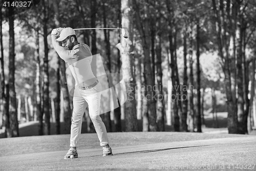 Image of golf player hitting shot with club