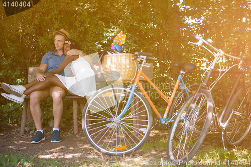 Image of Young multiethnic couple having a bike ride in nature