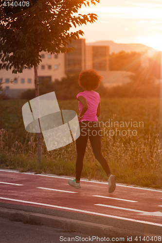 Image of a young African American woman jogging outdoors