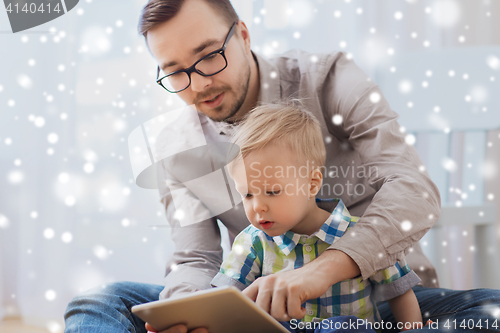 Image of father and son with tablet pc playing at home