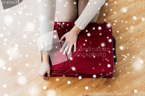 Image of close up of woman packing travel bag for vacation