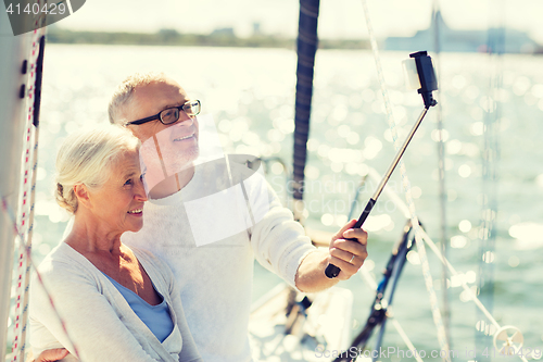 Image of senior couple taking selfie on sail boat or yacht