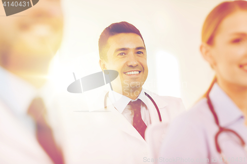 Image of happy doctor over group of medics at hospital
