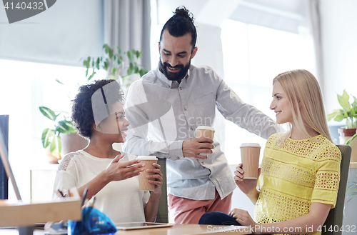 Image of happy creative team drinking coffee in office