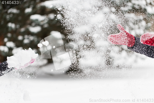 Image of happy friends playing with snow in winter