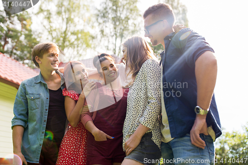 Image of happy teenage friends hugging at summer garden