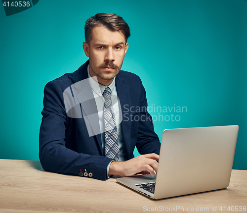 Image of Sad Young Man Working On Laptop At Desk