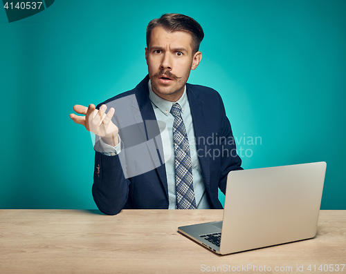 Image of Sad Young Man Working On Laptop At Desk
