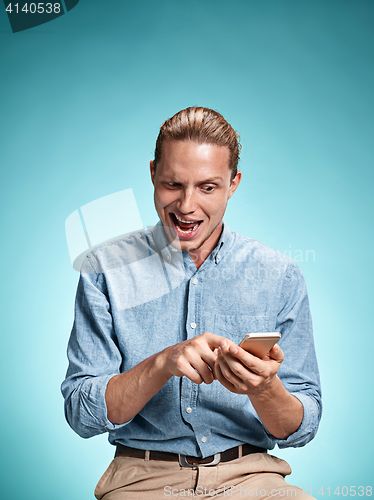 Image of The young surprised caucasian man on blue background