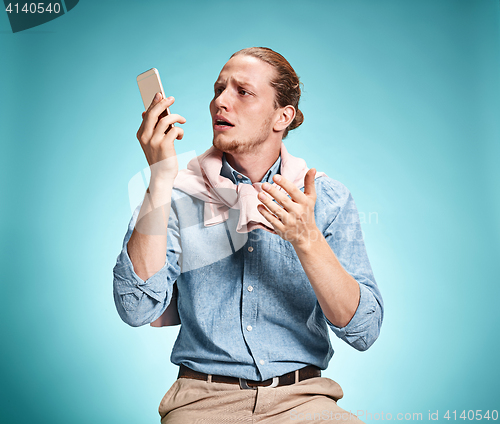 Image of The young surprised caucasian man on blue background