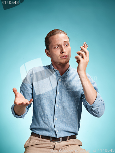 Image of The young surprised caucasian man on blue background