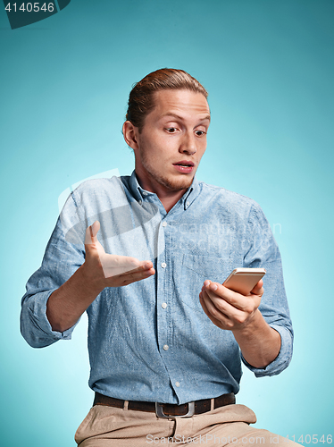 Image of The young surprised caucasian man on blue background