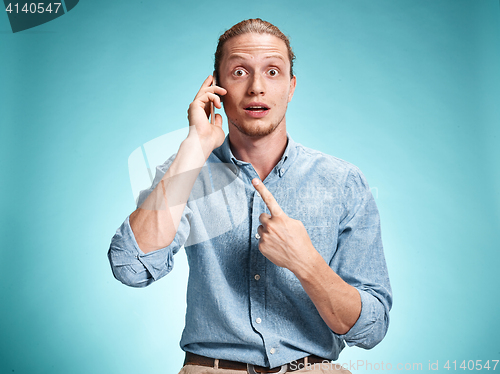 Image of The young surprised caucasian man on blue background