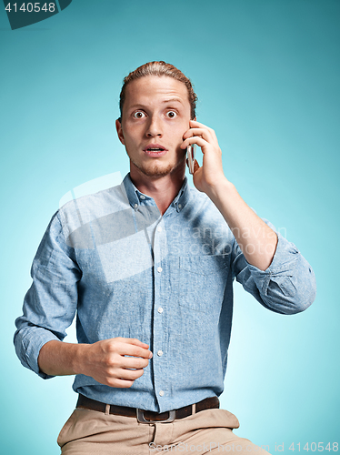 Image of The young surprised caucasian man on blue background