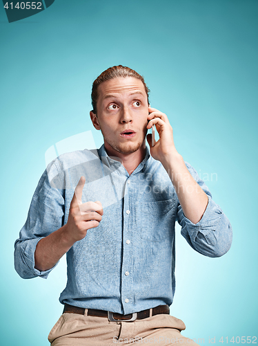 Image of The young surprised caucasian man on blue background