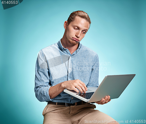 Image of Sad Young Man Working On Laptop