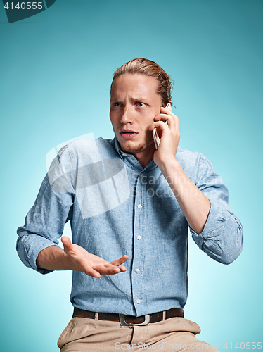 Image of The young surprised caucasian man on blue background