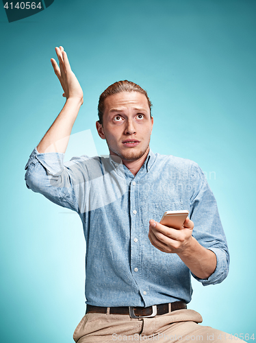 Image of The young surprised caucasian man on blue background