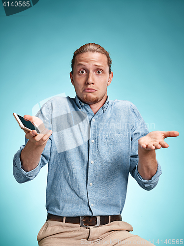 Image of The young surprised caucasian man on blue background