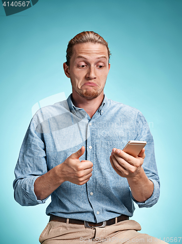 Image of The young surprised caucasian man on blue background