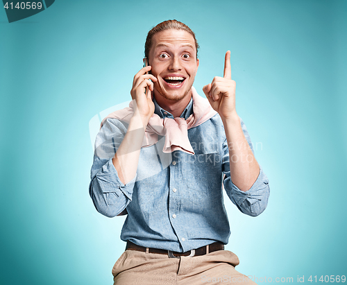 Image of The young smiling caucasian man on blue background