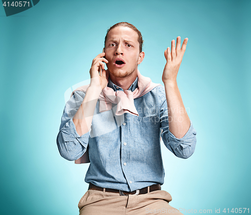 Image of The young surprised caucasian man on blue background