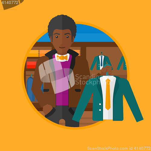 Image of Man holding suit jacket in clothing store.