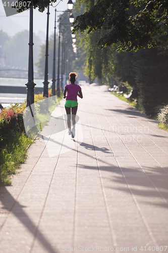 Image of african american woman jogging in the city