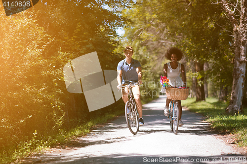 Image of Young multiethnic couple having a bike ride in nature