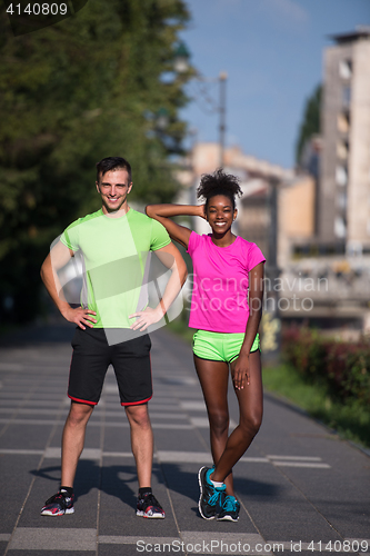 Image of portrait of young multietnic jogging couple ready to run