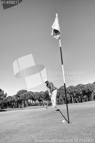 Image of golf player hitting shot with club on course