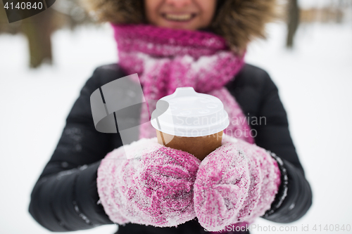 Image of close up of hand with coffee outdoors in winter